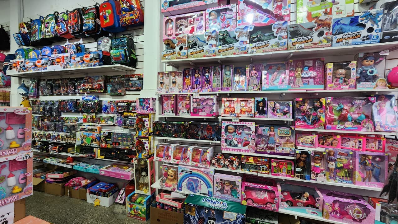 Estanterías de mochilas escolares y juguetes en Librería Arcoíris